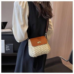 Detail showing handwoven straw crossbody bag with brown leather flap and gold twist lock