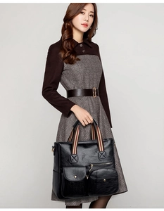 Close-up of black PU leather tote bag featuring striped handles and functional pockets