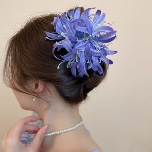 Détail de pince à cheveux fleur en tissu violet avec glands en soie pour coiffure chignon