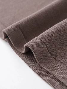 Close-up of high-density brown knitted fabric texture with smooth rolled edge details