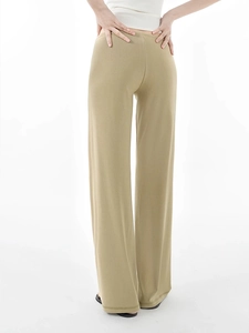 Detail view of khaki wide-leg casual pants showing draped fabric and back fit on model