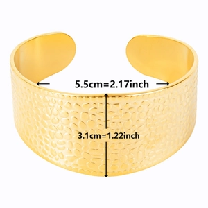 Macro detail of gold C-shape cuff bracelet showing hammered texture and dimensions