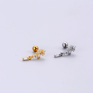 Detailed view of gold and silver stainless steel cartilage studs with zircon pendants
