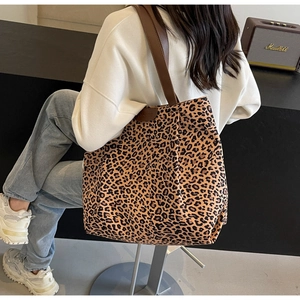 Détail du grand sac cabas en toile à motif léopard montrant la vue latérale sur un modèle