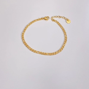 Close-up of polished gold Figaro chain bracelet with lobster clasp and extender