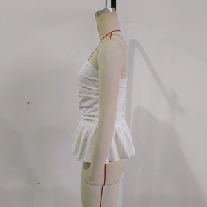 Detail of white strapless tube top with textured crinkle fabric and flared peplum hem