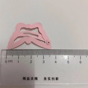 Detail view of a pink butterfly hair clip showing 5.3cm length measurement on a ruler