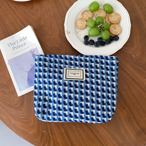 Texture détaillée de la pochette tissée à carreaux bleus et blancs avec étiquette