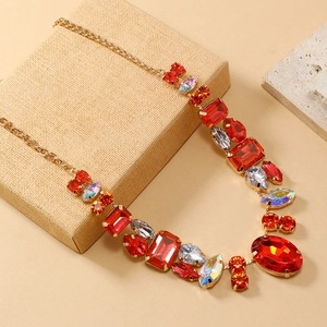 Detailed close-up of a vintage statement necklace with red and AB crystals in gold setting