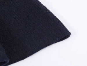 Macro detail of high-density navy blue knit fabric texture showing premium fiber weave