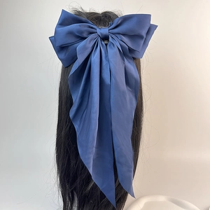 Vue arrière détaillée d'un grand nœud en satin bleu marine avec de longs rubans élégants