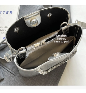 Detailed interior of silver chain bucket bag with magnetic closure and zipper pocket