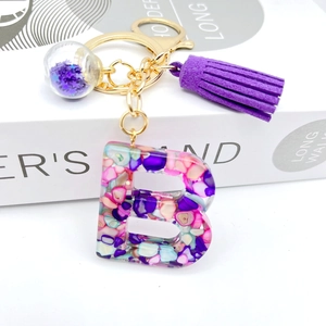 Purple resin letter B keychain with matching tassel and gold hardware on white background
