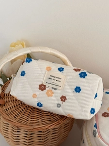 Close-up of corduroy makeup bag with blue floral pattern and quilted texture