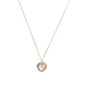 Minimalist gold necklace featuring a shell heart pendant with vintage embossed patterns