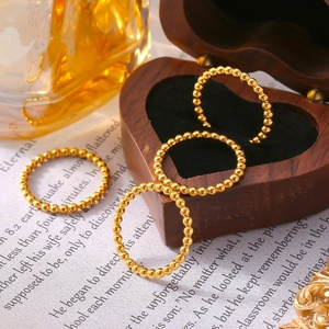 Minimalist gold plated titanium steel beaded ring displayed on a heart wooden box
