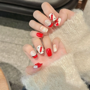 Unghie finte rosse fatte a mano con perle 3D e motivi a cuore per un look festivo