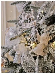 Macro detail of glittery Christmas angel, Merry Christmas sign, and silver mesh ribbon