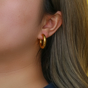 Close-up of model wearing chunky 18K gold plated stainless steel hoop earring