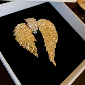 Macro detail of golden angel wing brooch with sparkling rhinestones in a gift box