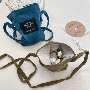 Detail of corduroy drawstring crossbody bags showing texture and internal storage capacity