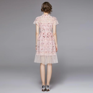 Vue arrière d'une robe en tulle rose avec broderies florales et manches volantées