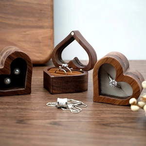 Macro detail of heart-shaped walnut wood ring box with velvet lining and metal hinges