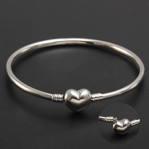 Polished silver stainless steel heart clasp bangle with threaded ends on black background