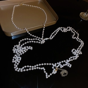 Detail of multi-layer pearl body chain with golden lobster clasp and adjustable link