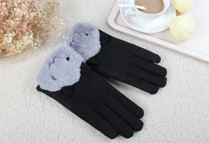 Close-up of black suede winter gloves with grey plush cuffs and cute cartoon ears