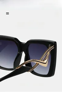 Detail of gold wave metal temples on oversized square block sunglasses for women