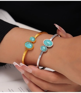 Detail of bohemian gold and silver open bangles with inlaid green stones on a model