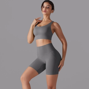 Dettaglio dei pantaloncini yoga grigi a vita alta e del reggiseno sportivo coordinato