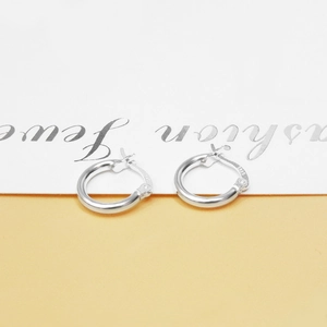 Close-up of minimalist S925 sterling silver hoop earrings with clear hallmark engraving