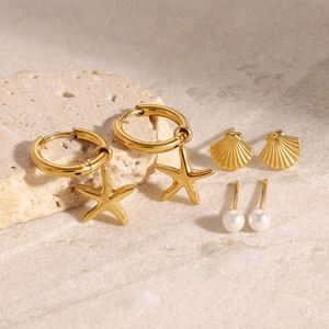 Détail d'un ensemble de boucles d'oreilles étoile de mer, coquillages et perles blanches