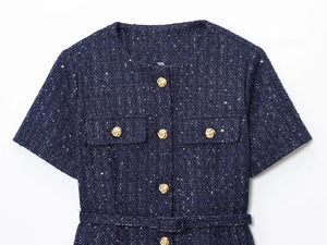 Dettaglio del tessuto in tweed blu navy con paillettes e bottoni dorati decorativi