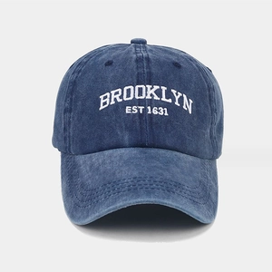 Detailed macro view of white BROOKLYN EST 1631 embroidery on washed cotton baseball cap