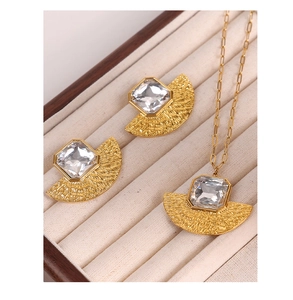 Detailed view of gold fan-shaped jewelry set with clear crystals in a beige velvet box