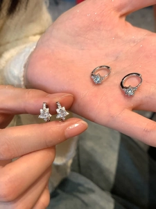 Detail de boucles d oreilles etoile en argent avec zircons tenues dans la main
