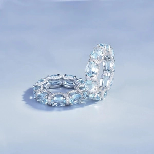 Detailed view of silver rings featuring oval light blue gemstones and micro-pave diamonds