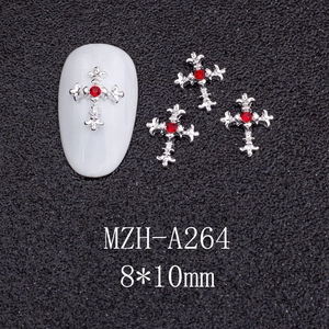 Macro shot of silver cross nail charm with red rhinestone detailing, 8x10mm size