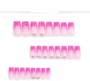 Detail of pink gradient press-on nails featuring 3D floral petals and subtle rhinestones