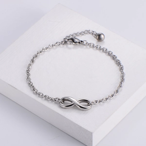 Elegant silver infinity symbol bracelet in stainless steel on white stone background