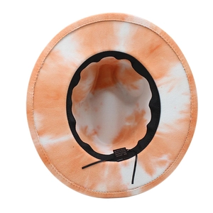 Detail view of the tie-dye pattern and internal care label of the wide brim fedora hat