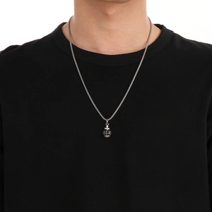 Detail showing a vintage crown pendant necklace with cross design on a model