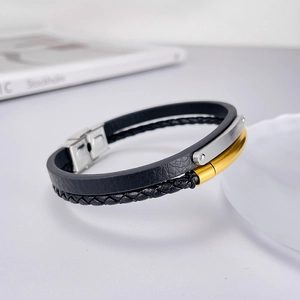 Détail d'un bracelet double couche en cuir noir et corde tressée avec fermoir en métal chic