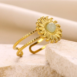 Detailed macro view of vintage gold sunburst ring with turquoise stone on textured rock