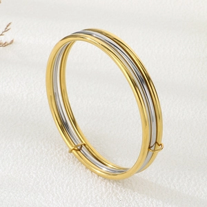 Detail of adjustable 3-ring stainless steel bangle in gold and silver mirror finish