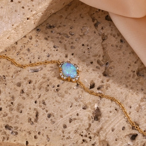 Macro view of a gold-plated flower petal bracelet with a blue opal stone centerpiece