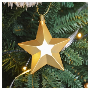 Golden star ornament with white center hanging on a festive Christmas tree detail